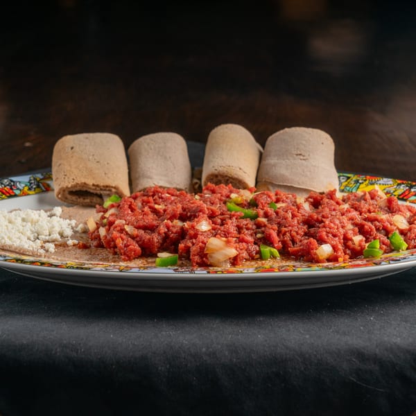 Ethiopian Kitfo, a dish of minced raw beef, with injera bread and a side of white cheese.