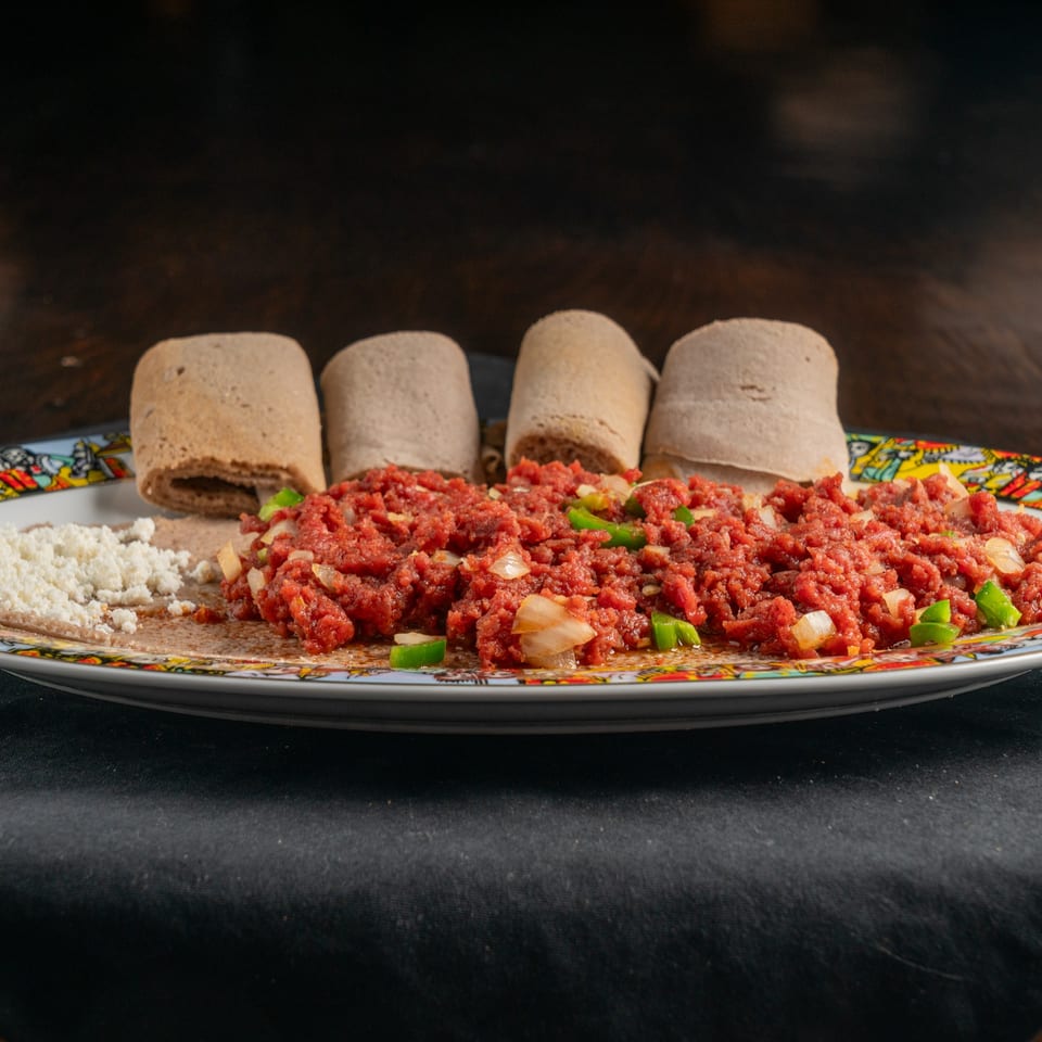 Ethiopian Kitfo, a dish of minced raw beef, with injera bread and a side of white cheese.